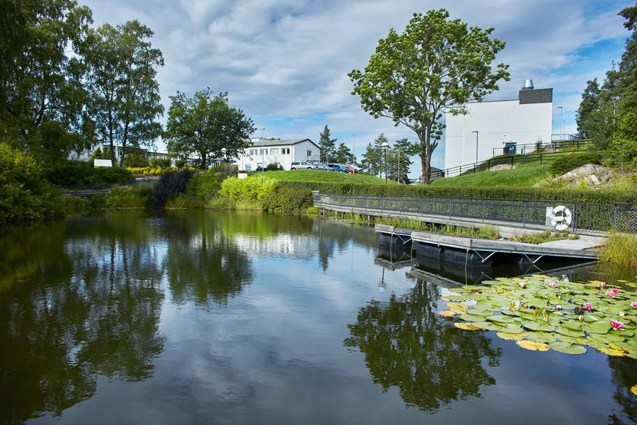 In the foreground, we see the fish pond at Sunnaas Rehabilitation Hospital, with the hospital buildings in the background.