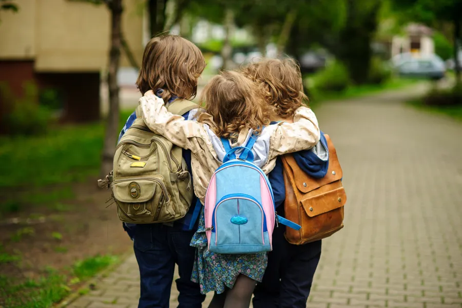 Tre skolebarn med ryggsekk