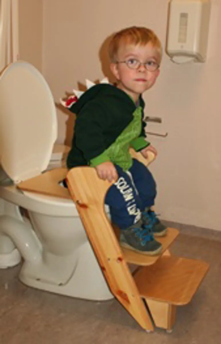 En gutt som sitter på et toalett